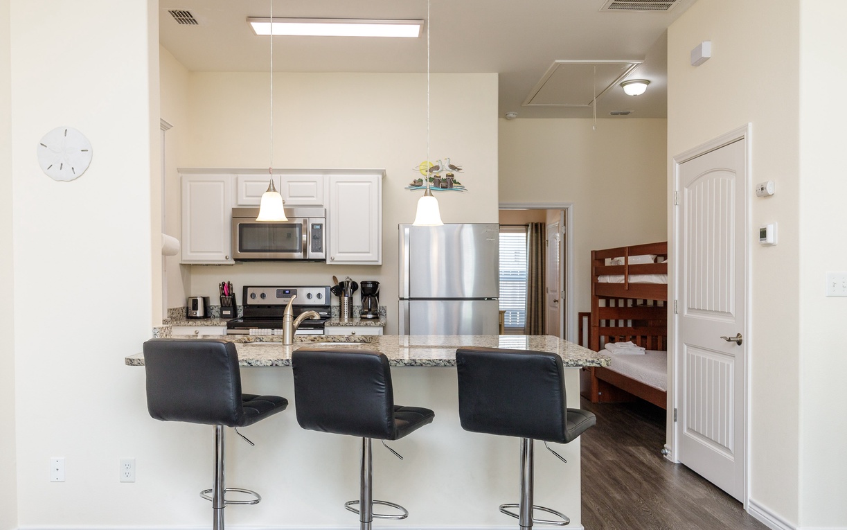 Your sleek modern kitchen features granite counters, stainless appliances, and a breakfast bar perfect for morning coffee or casual meals.