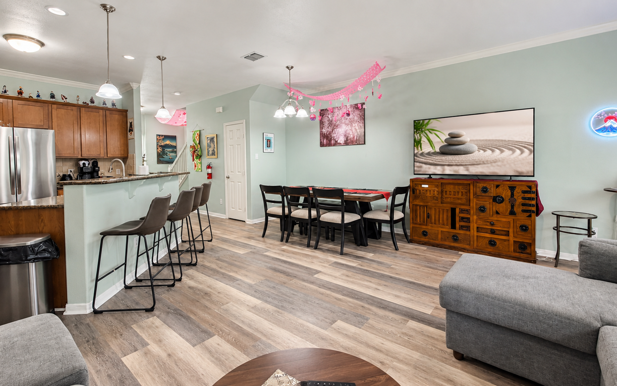 Step into your spacious open-concept living area, where natural wood tones and soft greens create a calming retreat. Your kitchen bar invites morning coffee, while the dining table awaits shared meals and laughter.