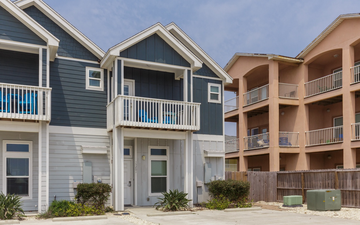 Modern coastal townhomes feature covered balconies and contemporary design in this beachside community.