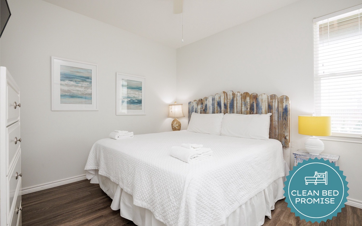 Wake up refreshed in your bright, coastal-themed bedroom with driftwood headboard and ocean artwork.