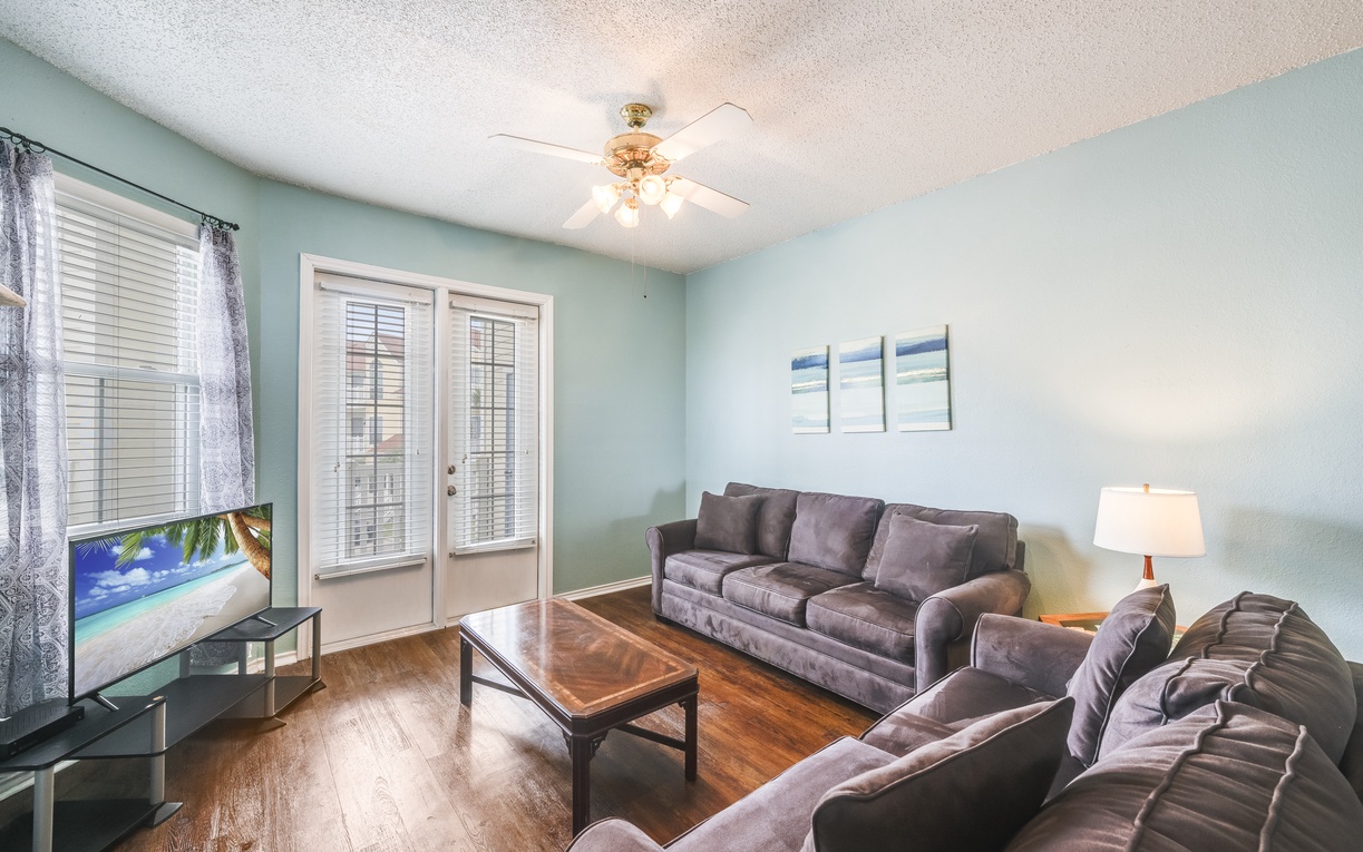 Cozy living area featuring plush seating, a coffee table for games or snacks, and private patio access for enjoying the coastal breeze.