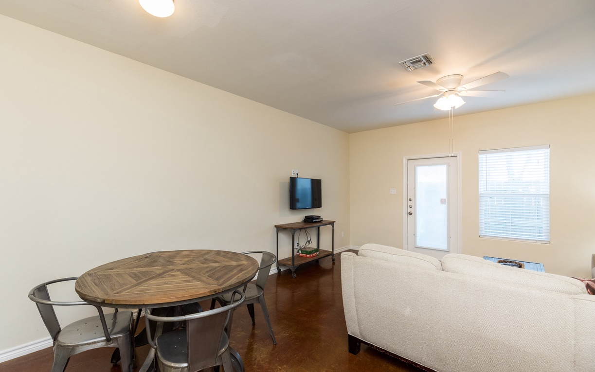 Relax in your bright, comfortable living space with dining table, plush sofa, and entertainment center ready for your stay.