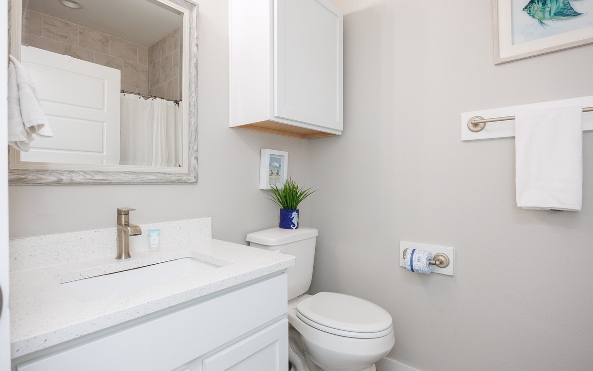 Step into your pristine bathroom featuring a spacious vanity, fresh towels, and thoughtful coastal touches that make you feel right at home.