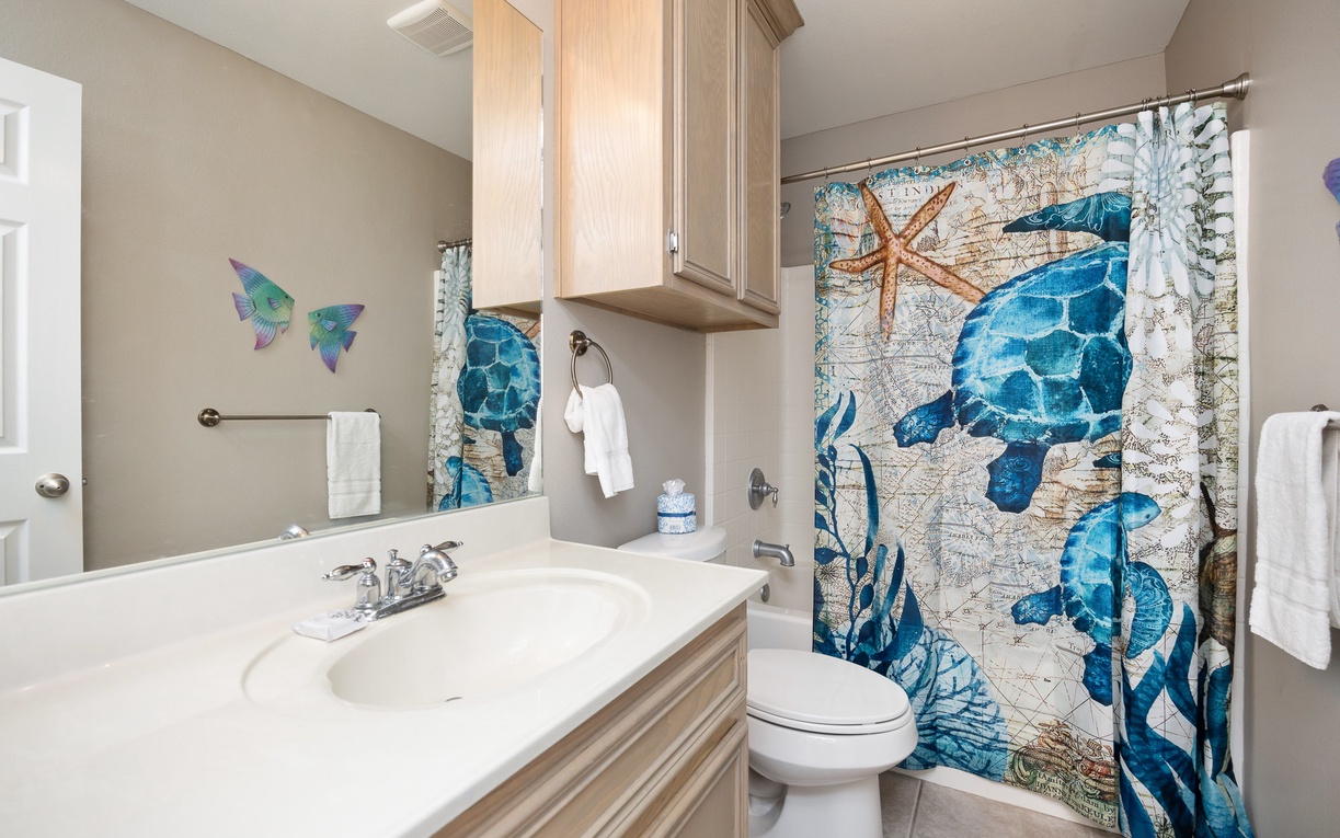 Refresh in your ocean-themed bathroom with whimsical sea turtle shower curtain and coastal charm throughout.