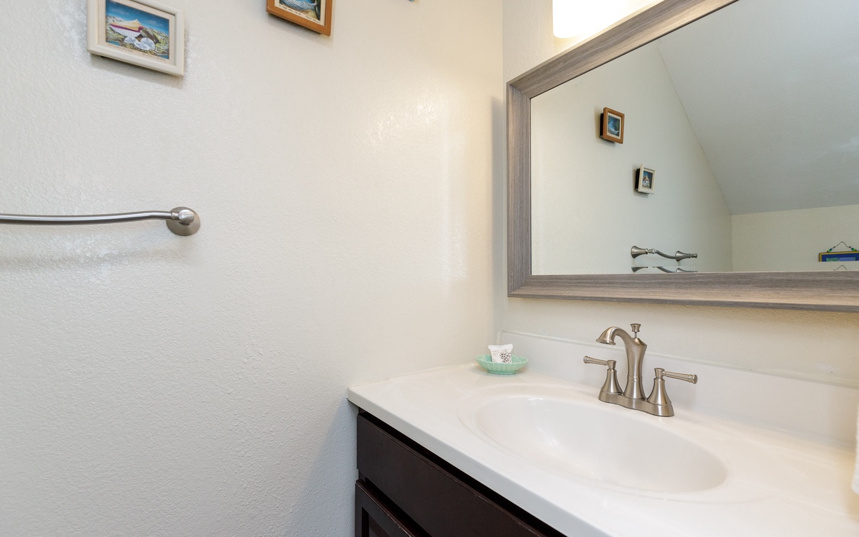 Refresh in your first floor half bathroom featuring elegant fixtures, ample counter space, and thoughtful coastal touches that make every morning feel special.