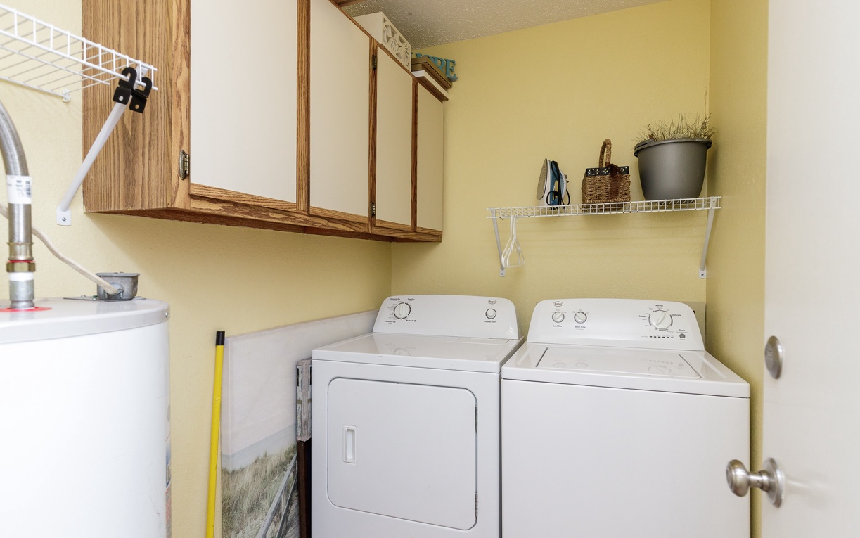 Keep your clothes fresh in this well-organized laundry room with full-size washer and dryer, plus handy storage and folding space.