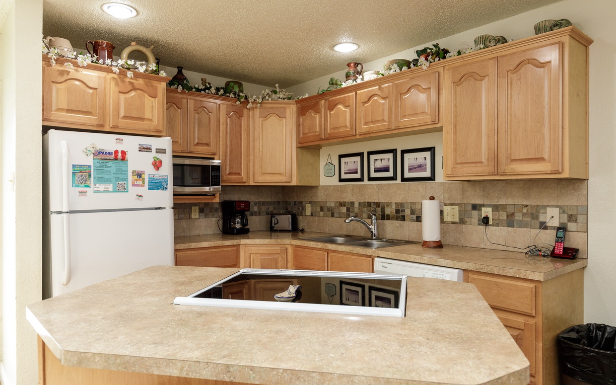 Your fully equipped kitchen awaits with warm wood cabinets, granite counters, and modern appliances for creating memorable meals during your stay.