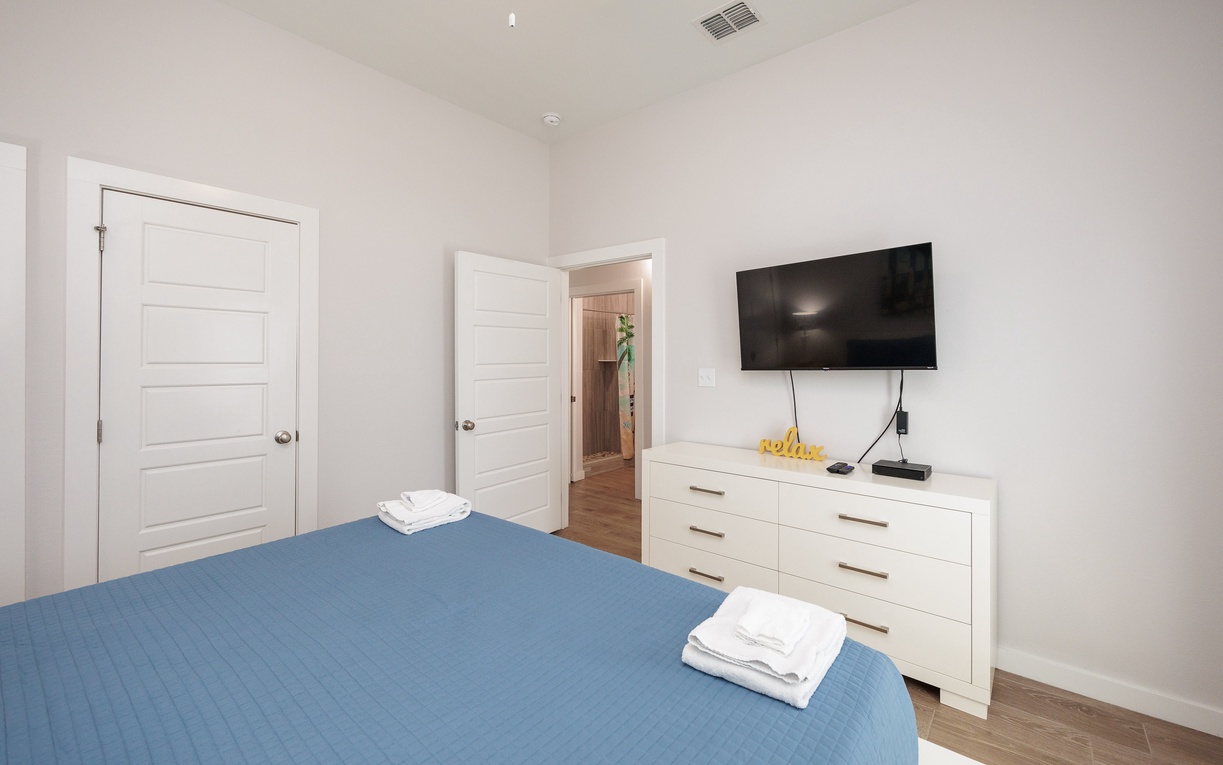 Relax in your bright, contemporary bedroom with wall-mounted TV and crisp linens for comfortable nights.