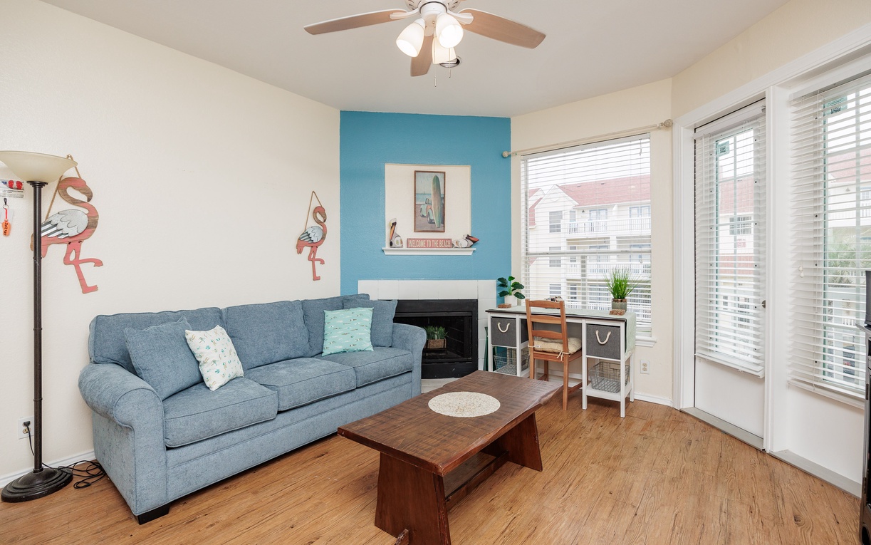 Relax on your comfy sofa beneath the gentle ceiling fan, while natural light streams through sliding doors to your private balcony.