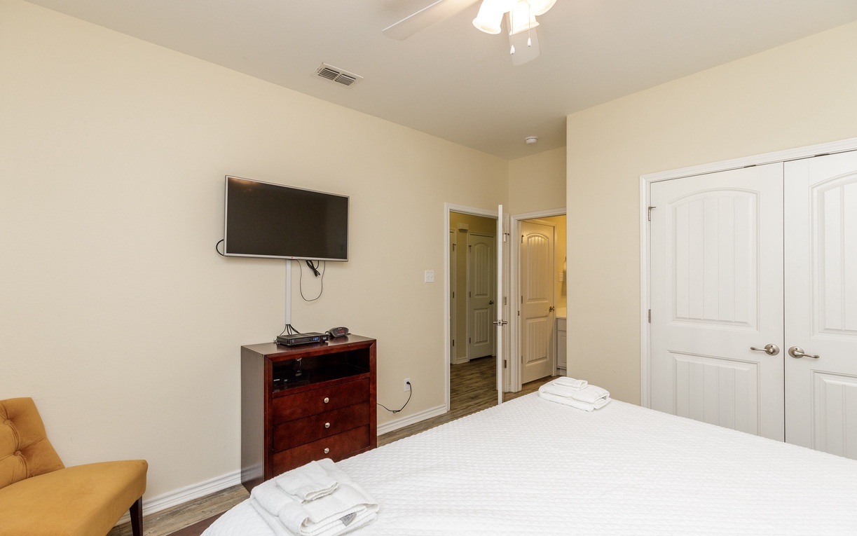Sink into crisp linens while enjoying your favorite shows on the wall-mounted TV in this serene bedroom retreat.