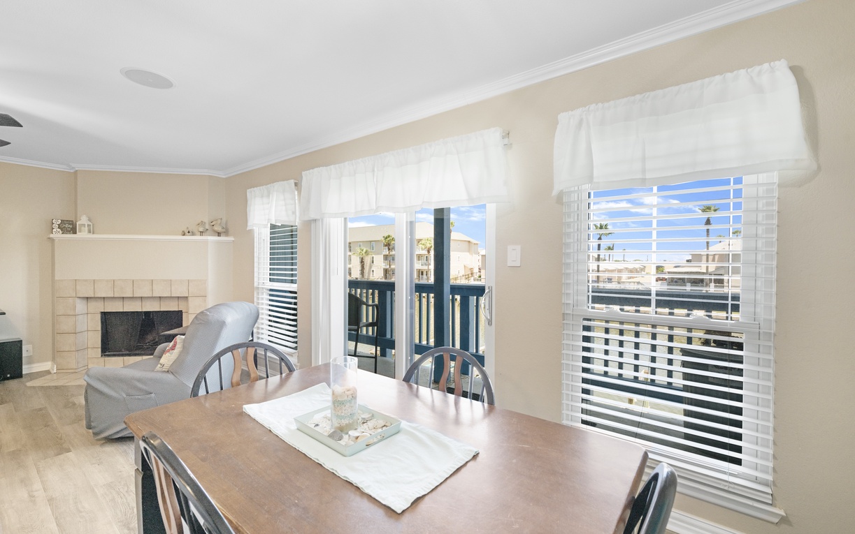 Gather around your spacious dining table, where natural light streams through white blinds and sliding doors lead to your private balcony.