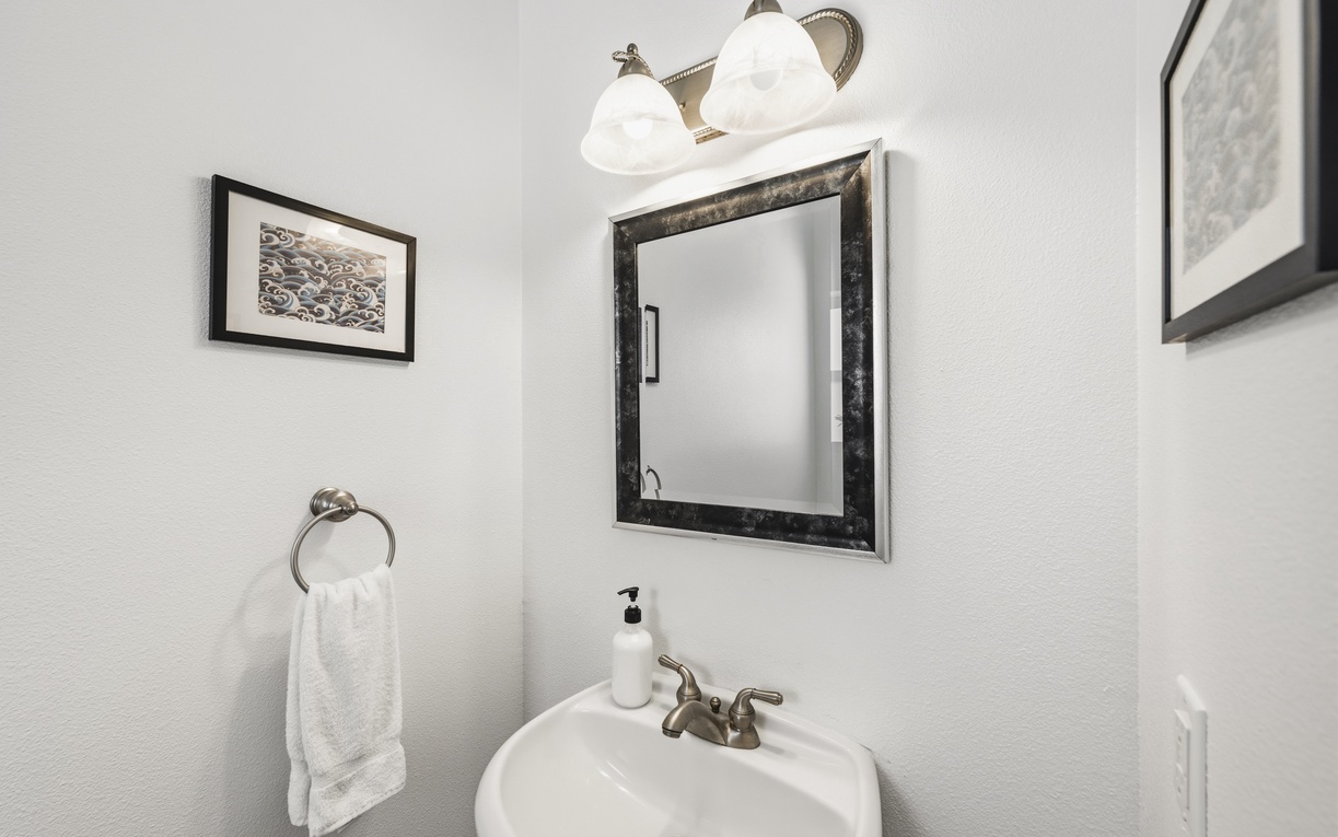 Freshen up in this bright, stylish bathroom with a framed mirror, elegant vanity lighting, and soft towels waiting for you after a day of adventure.