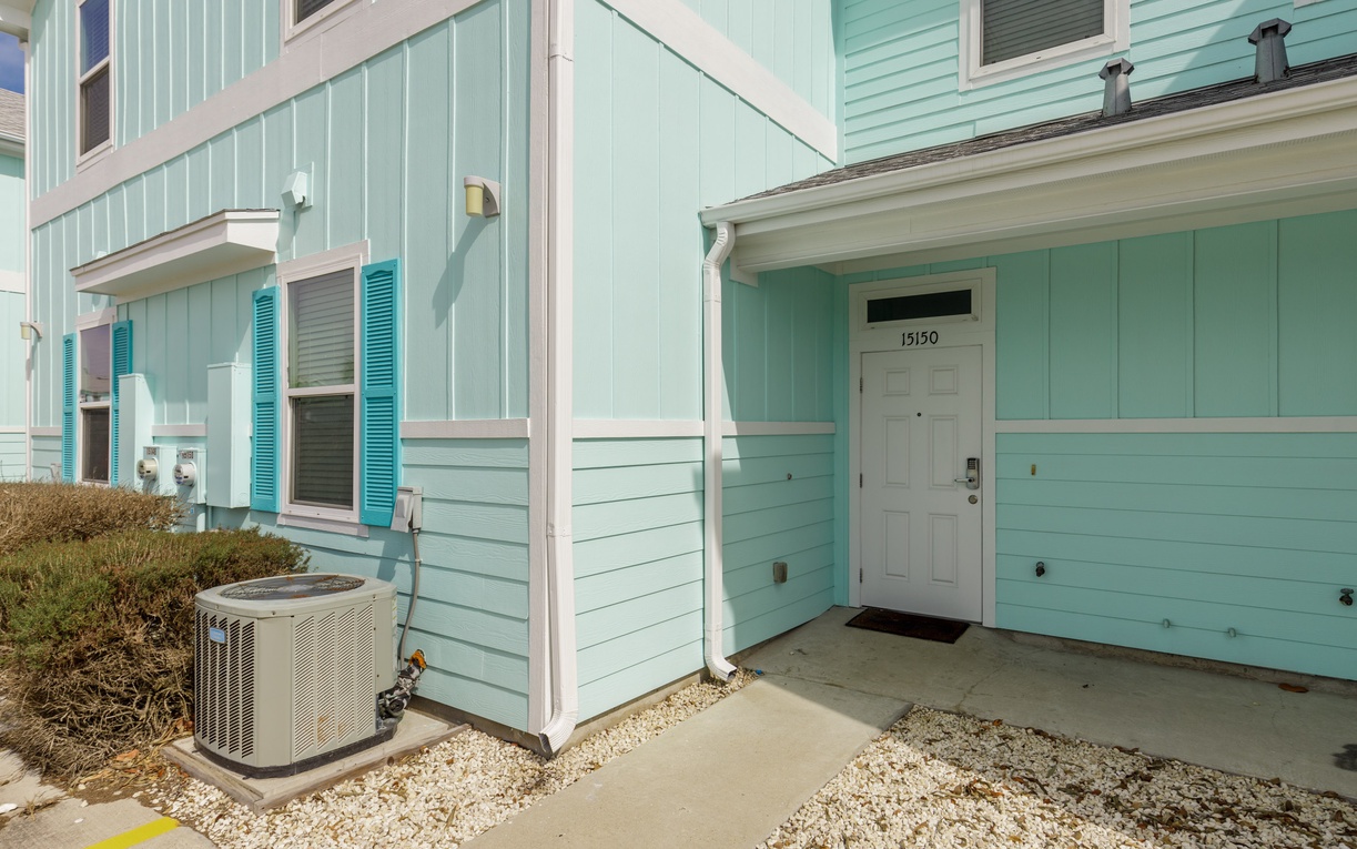 Charming seafoam green beach cottage with white trim and teal shutters creates a welcoming coastal retreat.