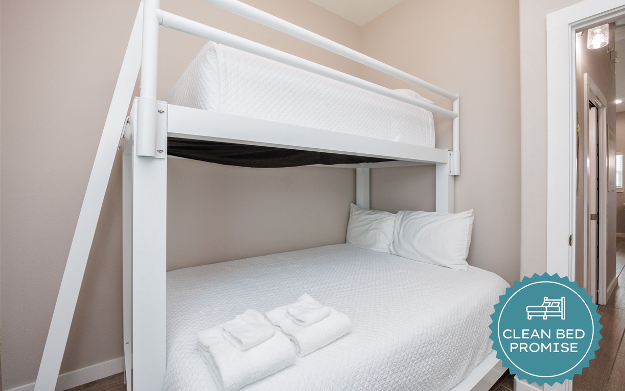 Your cozy bunk bed sanctuary awaits, with crisp white linens and fluffy towels ready for a restful night's sleep.