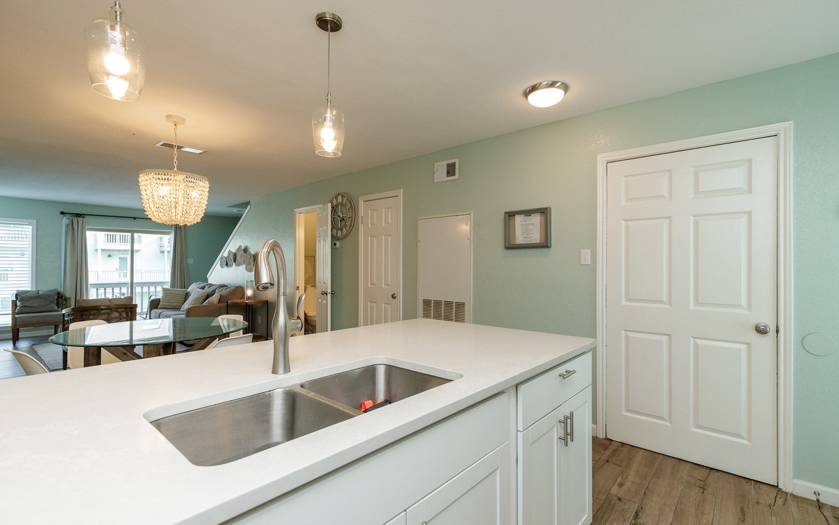 Your open kitchen flows seamlessly into the living space, with modern fixtures and calming mint walls creating the perfect atmosphere for cooking.