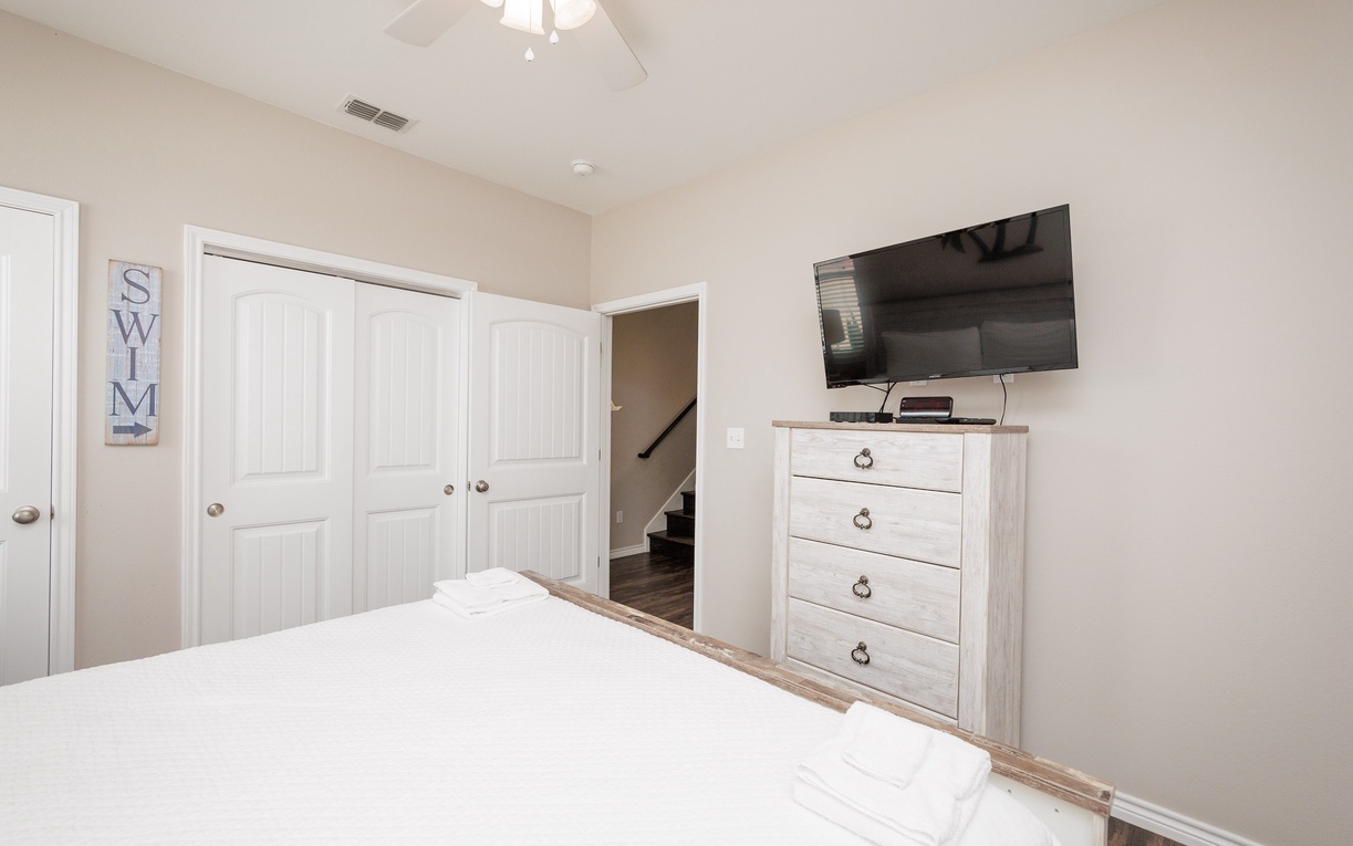 Relax in your bright, serene bedroom featuring a plush bed, flat-screen TV, and ample storage space for all your vacation essentials.