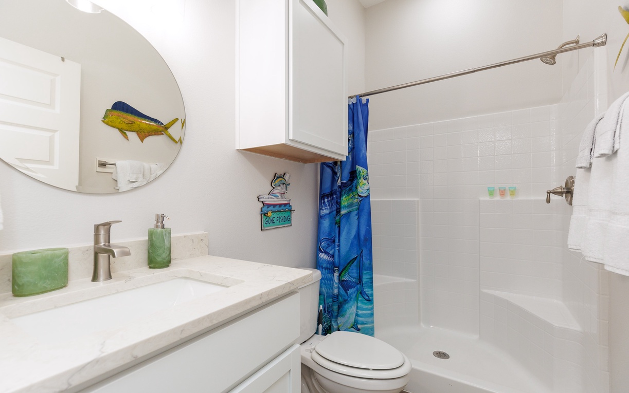 Refresh in your private bathroom featuring a spacious walk-in shower, modern vanity, and charming coastal touches that make getting ready a delight.