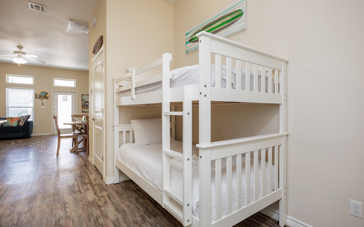 Your kids will love these cozy white bunk beds with fresh linens, perfect for sharing bedtime stories and creating vacation memories together.