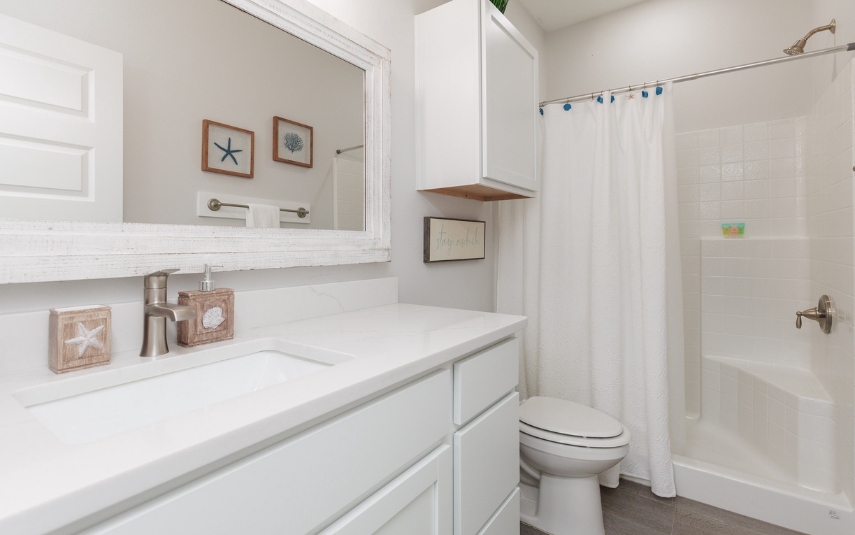 Refresh in your bright, coastal-themed bathroom with crisp white finishes, nautical touches, and a relaxing tub-shower combo.