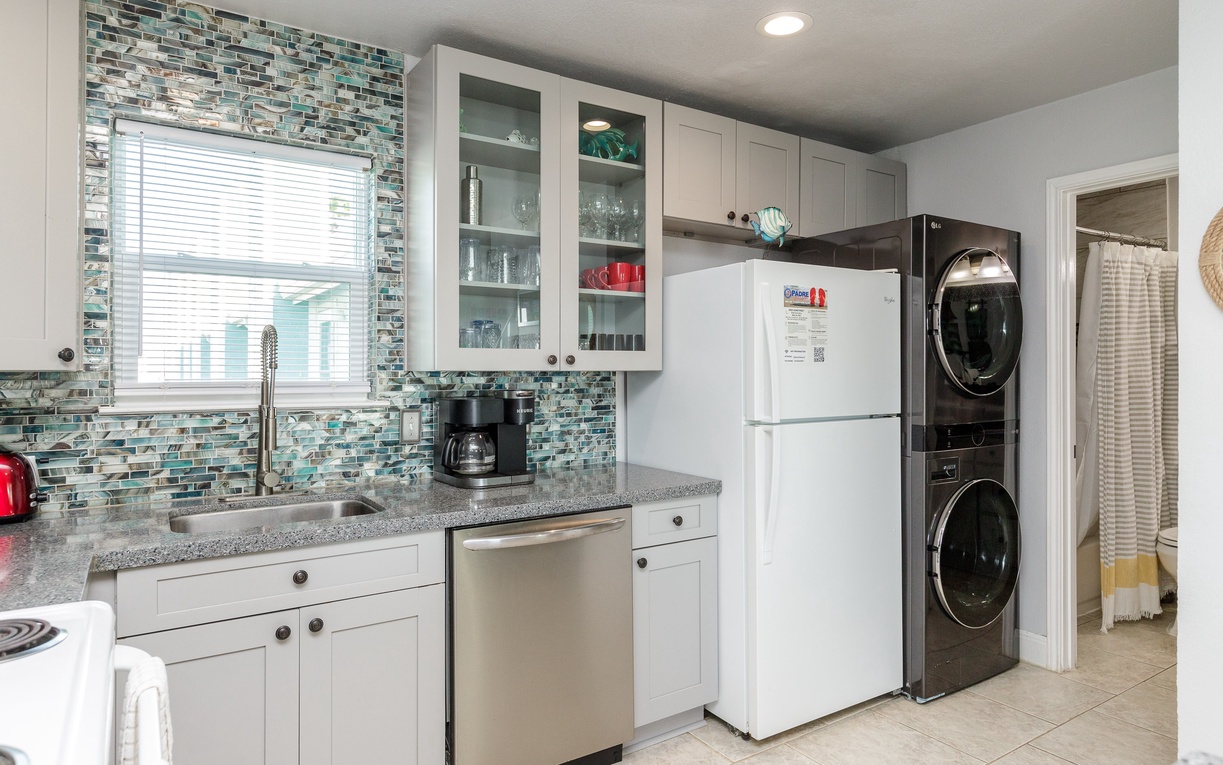 Cook your favorite meals in this bright kitchen featuring modern appliances, granite counters, and stunning glass tile backsplash.