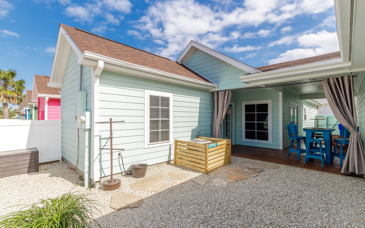 Charming coastal cottage with covered patio where you can dine outdoors and enjoy the beach-inspired architecture.