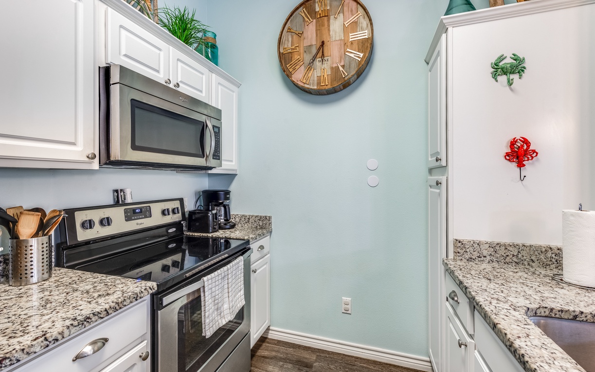 Cook your favorite meals in this fully equipped galley kitchen with granite counters, modern appliances, and coastal charm.
