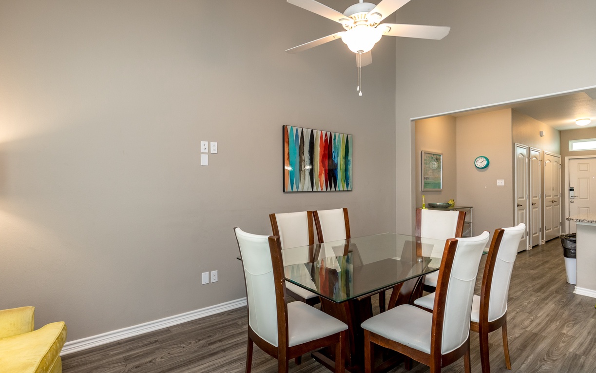 Gather around your elegant glass dining table for memorable meals with loved ones in this sophisticated space.