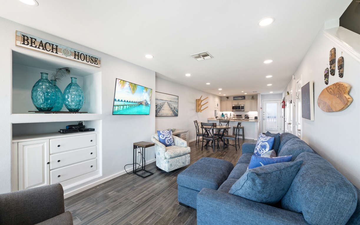 Settle into the plush coastal-inspired living room, where beach decor and soft blues invite you to relax. The open layout connects effortlessly to your dining and kitchen areas for easy living.