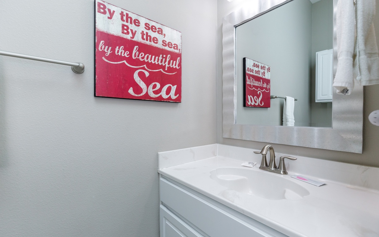 Freshen up in your charming coastal bathroom, where nautical decor and modern amenities create the perfect seaside retreat ambiance.