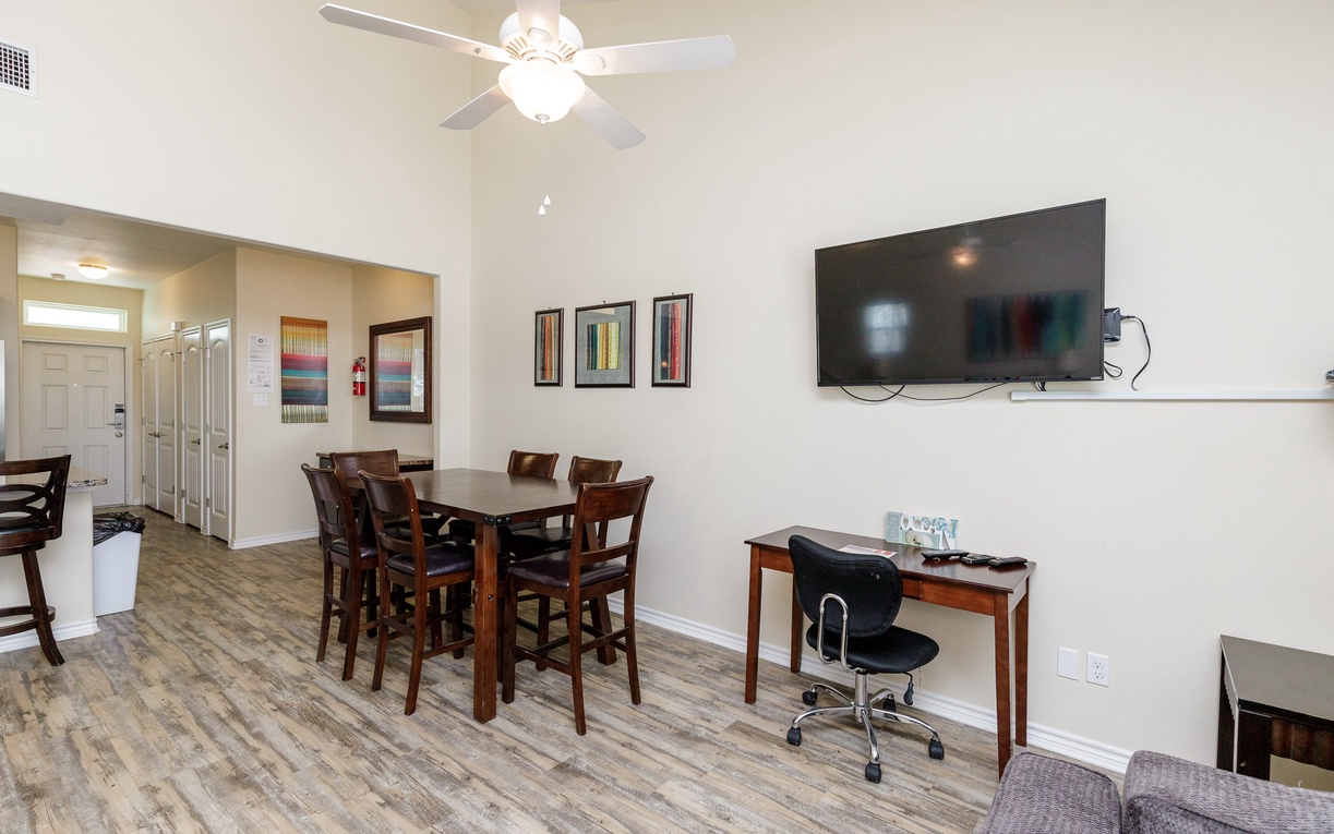 Your spacious dining area features rich wood furnishings and modern entertainment, perfect for family meals and remote work sessions.