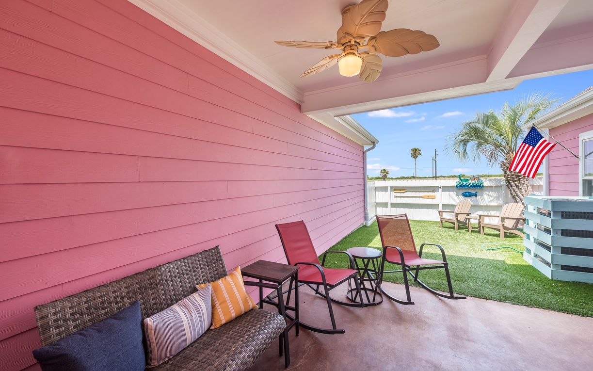 Relax on your covered patio with tropical ceiling fan, wicker seating, and rocking chairs overlooking the sunny yard.