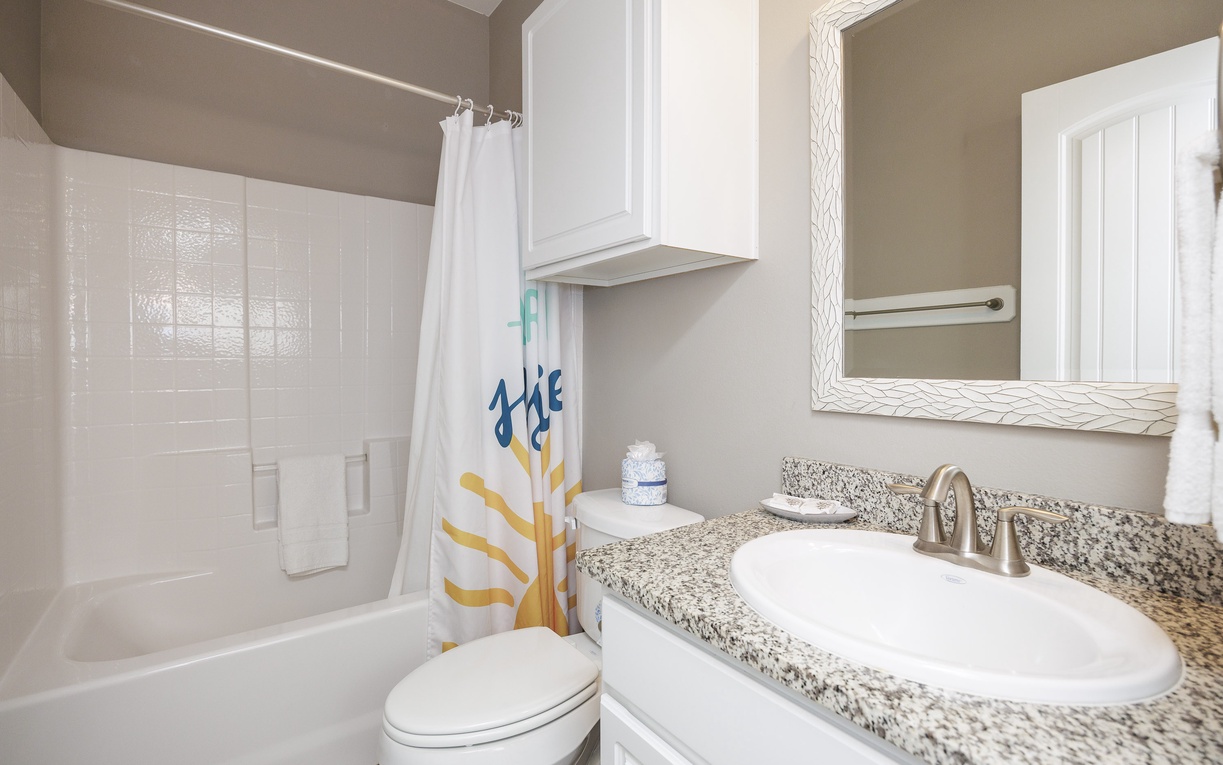 Your fresh bathroom features granite counters, cheerful sunshine curtain, and everything you need for comfortable stays.