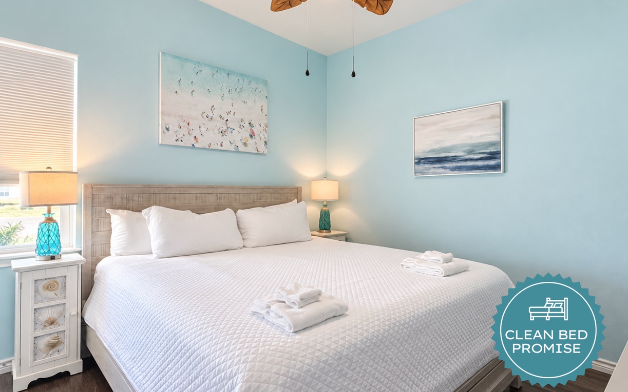 Slip into comfort in this serene coastal bedroom, where soft ocean hues and fresh linens welcome you. Drift off beneath the tropical ceiling fan and wake to gentle seaside light.