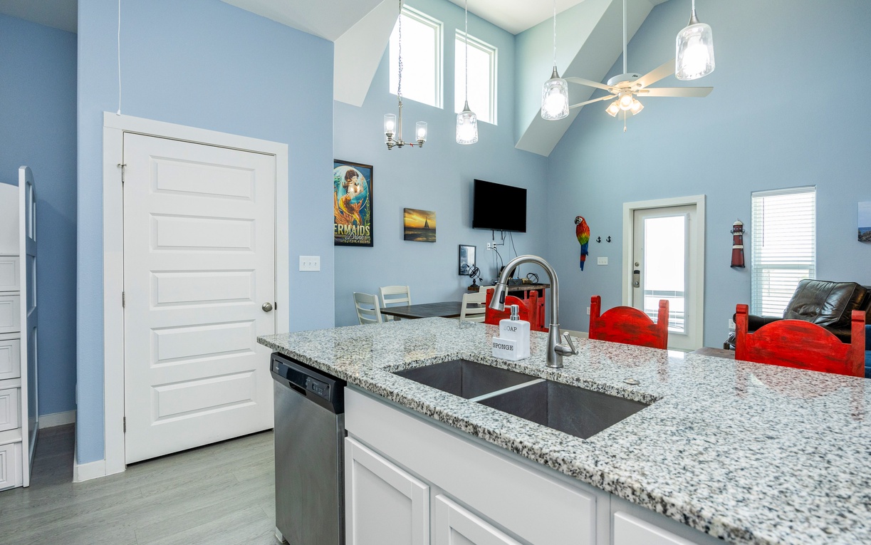 Your modern kitchen features gleaming granite countertops, stainless appliances, and bright pendant lighting—perfect for preparing meals together.