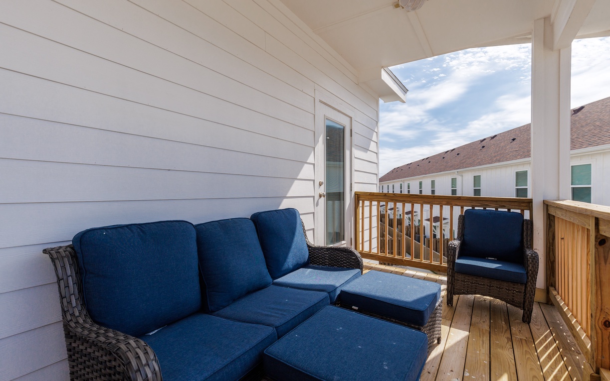 Relax on your private balcony with plush navy seating, perfect for morning coffee or evening conversations under open skies.