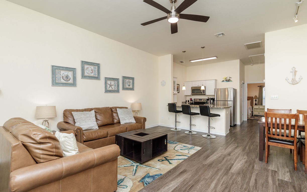Sink into plush leather sofas while the ceiling fan keeps you cool in this open-concept space that flows seamlessly to your modern kitchen.