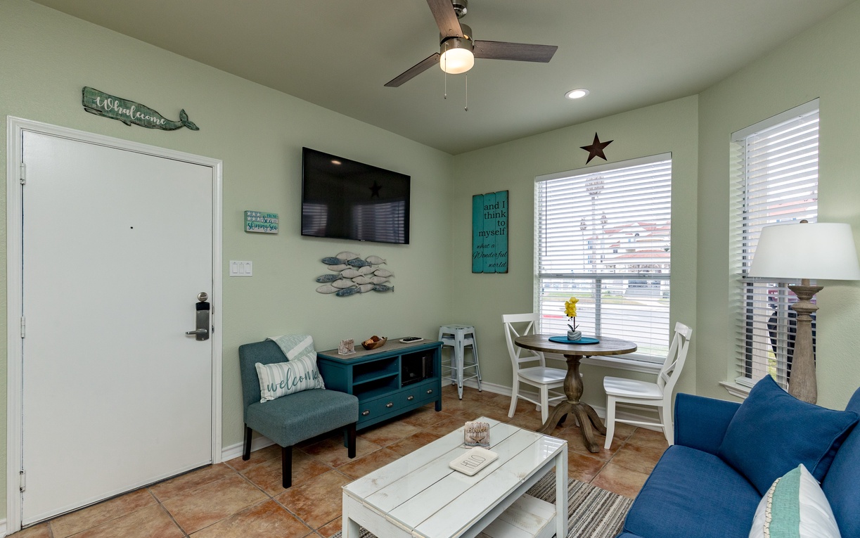 Relax in your bright, coastal-themed living space with comfortable seating, dining nook, and charming nautical touches throughout.