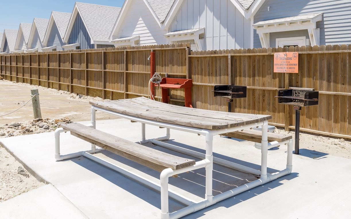 Charming beachside properties with dedicated BBQ area featuring picnic tables and grills for your perfect outdoor dining experience.
