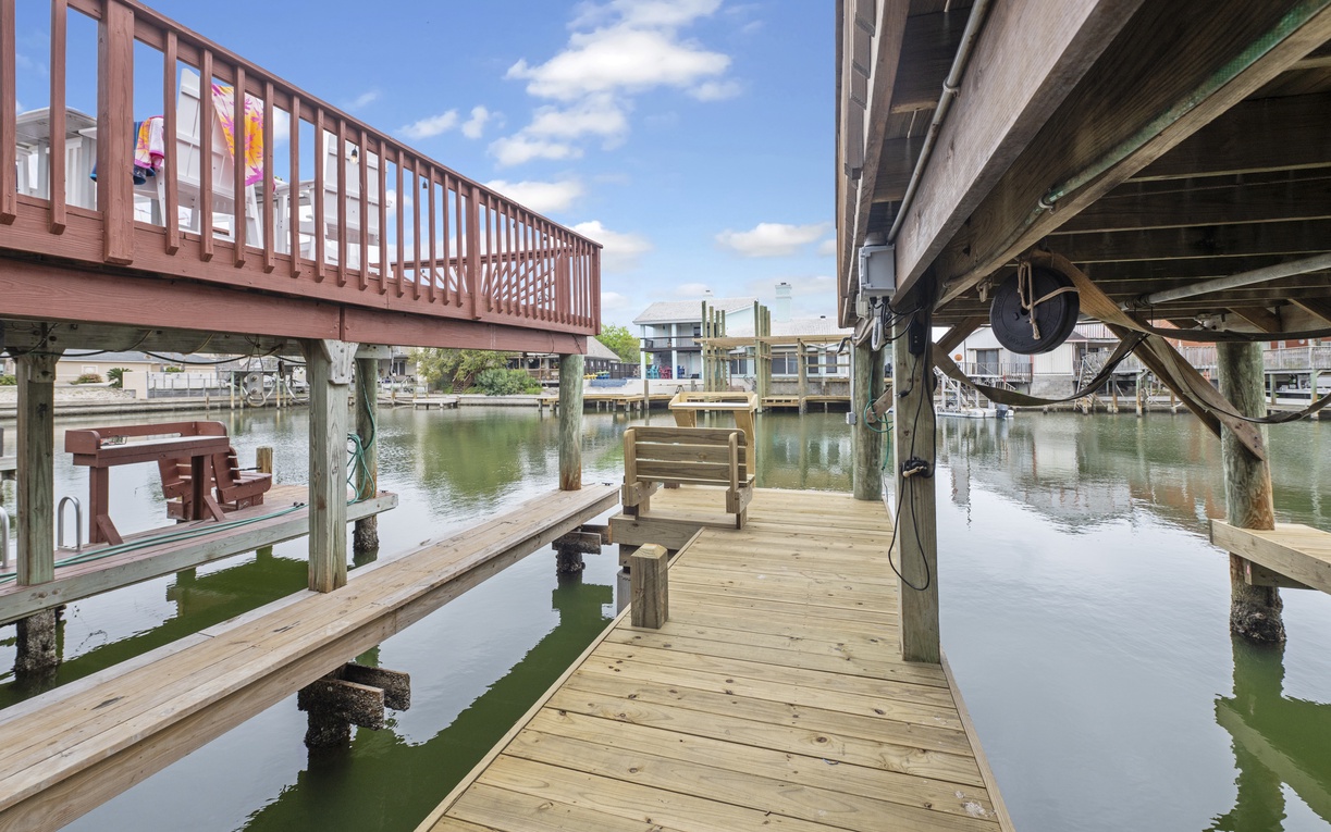 Your private waterfront dock awaits, where gentle waters lap beneath wooden planks and peaceful mornings begin with coffee overlooking the serene canal.