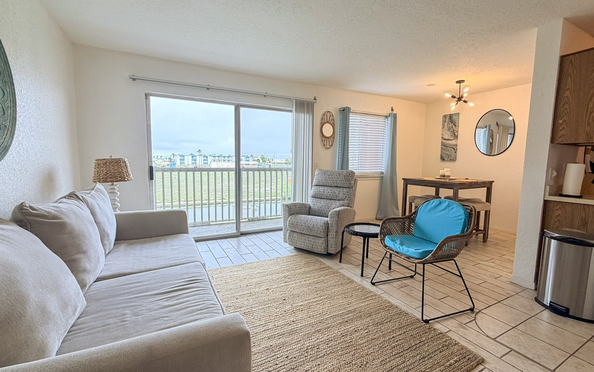 Settle into your spacious living area with comfortable seating, natural light streaming through large windows, and stunning views beyond.