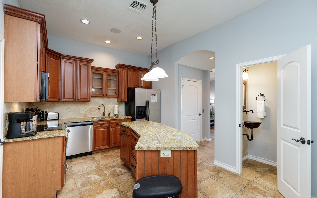Your fully equipped kitchen features granite counters, rich wood cabinetry, and modern appliances—perfect for creating memorable meals during your stay.
