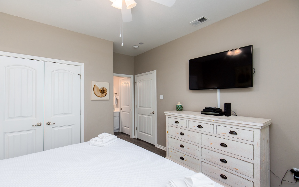 Unwind in your peaceful bedroom featuring a wall-mounted TV and spacious dresser for storing all your vacation essentials.