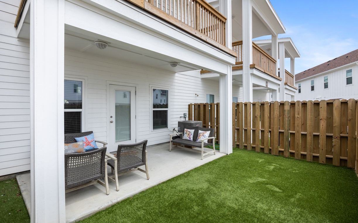 Step onto your private covered patio with comfortable seating overlooking a lush green lawn—perfect for morning coffee or evening relaxation.