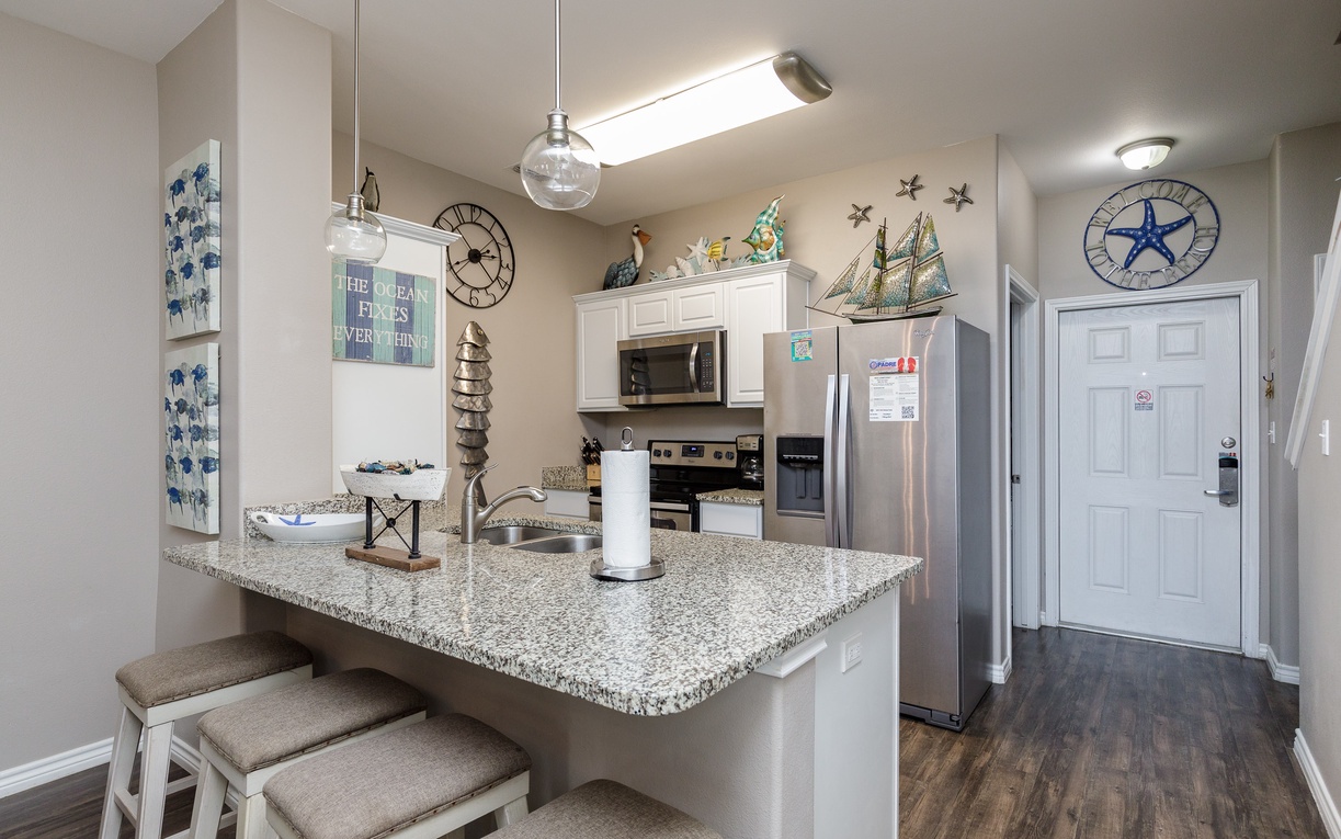 Your fully equipped kitchen awaits with granite countertops and nautical charm, perfect for preparing meals while enjoying coastal décor.