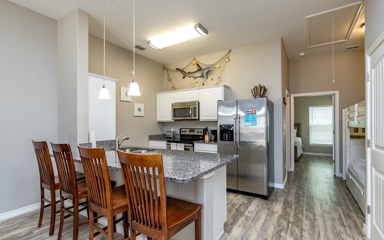 Your bright, modern kitchen invites home-cooked meals with granite counters, stainless appliances, and a cozy breakfast bar perfect for morning coffee.