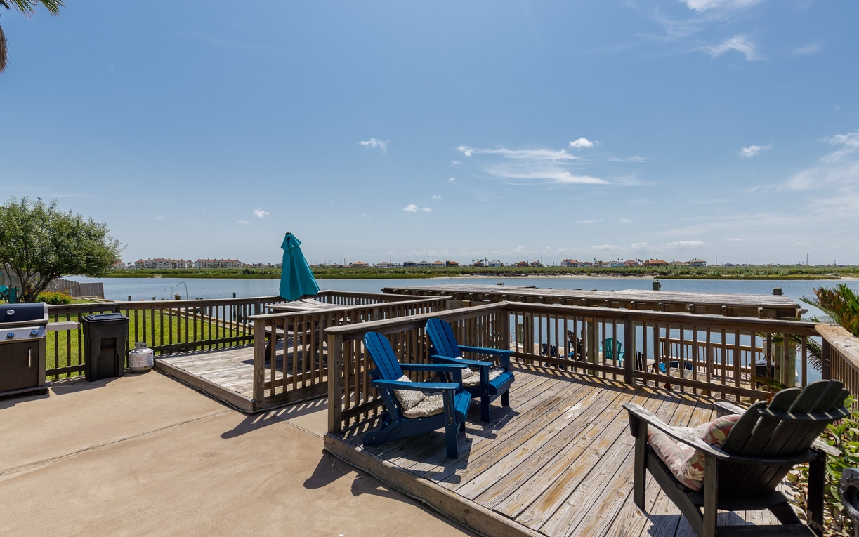 Unwind in your private waterfront deck with comfortable seating overlooking serene lake views and distant cityscape.