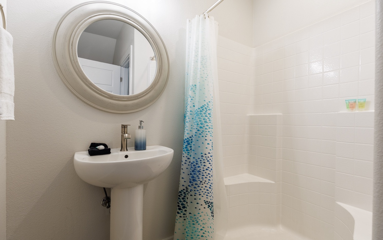 Your private bathroom features a refreshing shower, elegant pedestal sink, and thoughtful touches like complimentary toiletries to make your stay comfortable.
