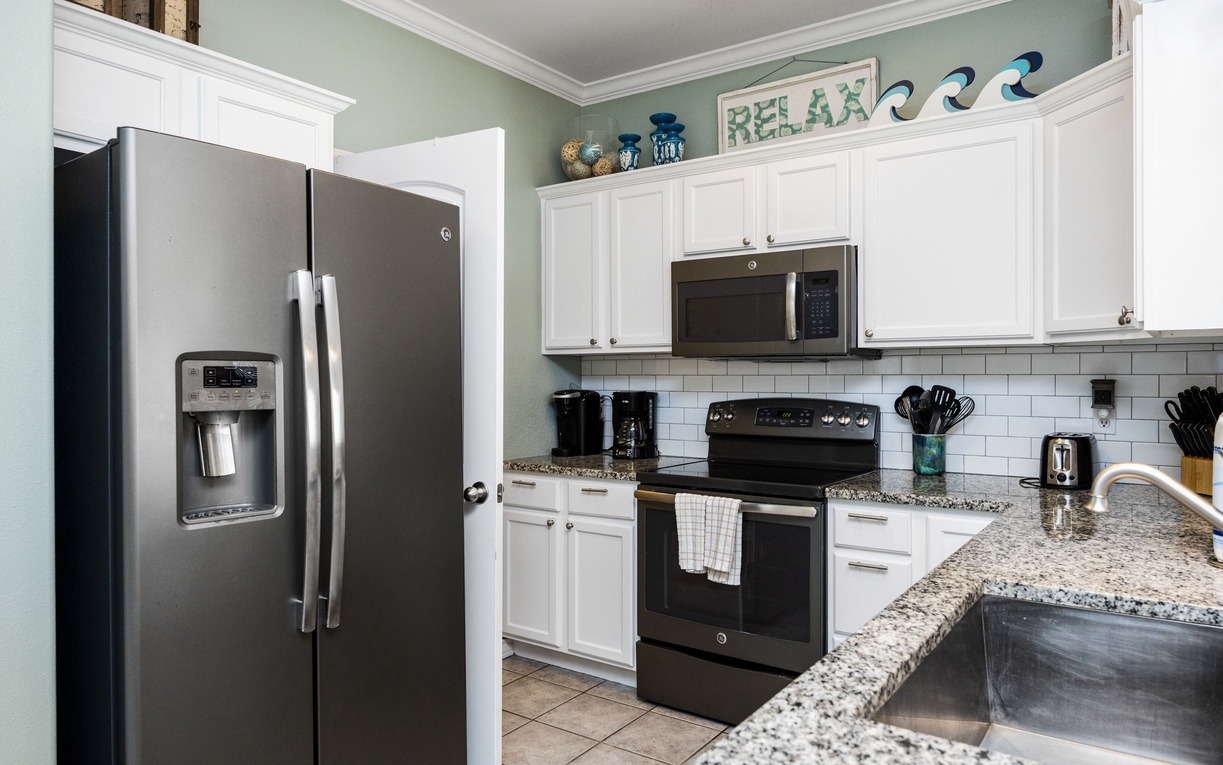 Your fully-equipped kitchen invites culinary adventures with granite counters, stainless appliances, and beach-themed touches that capture vacation vibes.