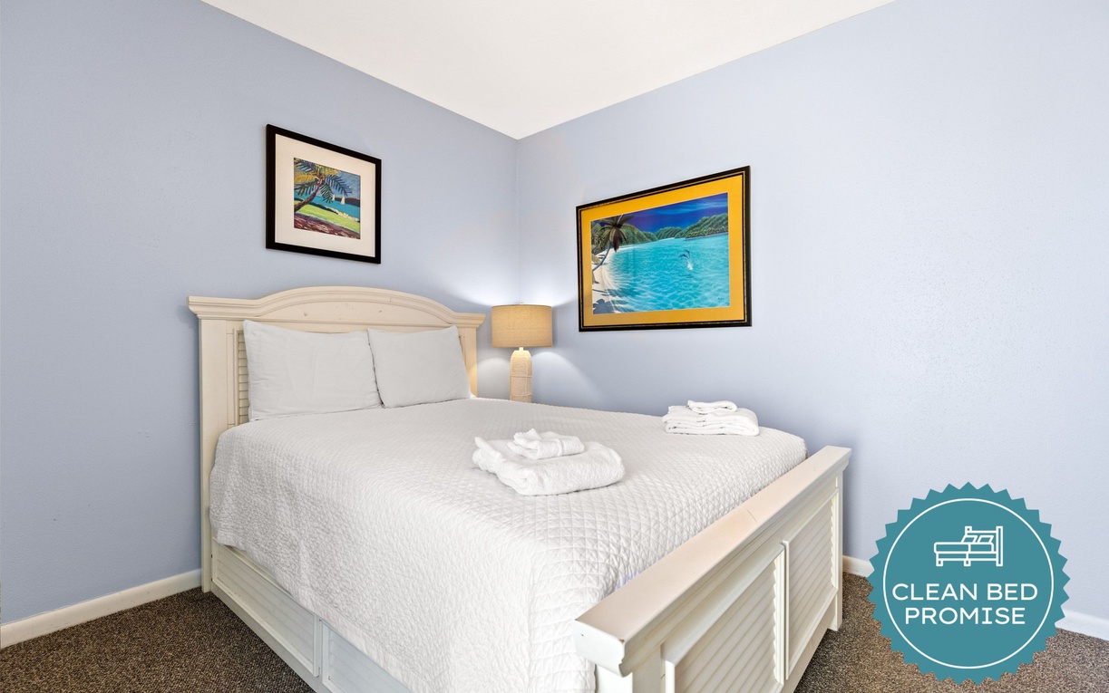 Drift into peaceful dreams in your cozy bedroom, where soft blue walls and cheerful tropical artwork create a calming retreat.