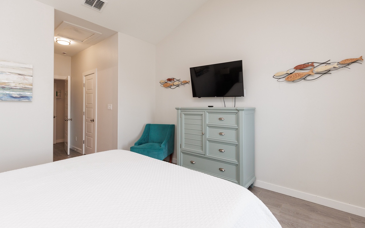 Your cozy bedroom features a comfortable bed, flat-screen TV, and charming coastal decor that creates the perfect retreat for restful nights.